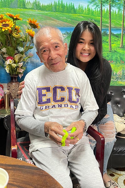 Chen poses with her grandfather in Taiwan in May 2023. He is holding a hand strengthening tool that she brought from North Carolina.