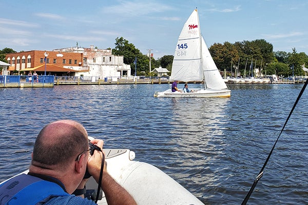 Hollis photographs an adaptive sailboat used by researchers in the Department of Recreation Sciences to teach disabled people to sail.