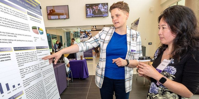 Anna Lobozinska, left, discusses her research with Ying Zhou during the 16th annual Global Partners in Education Conference inside East Carolina University's Main Campus Student Center. (ECU photo by Rhett Butler)