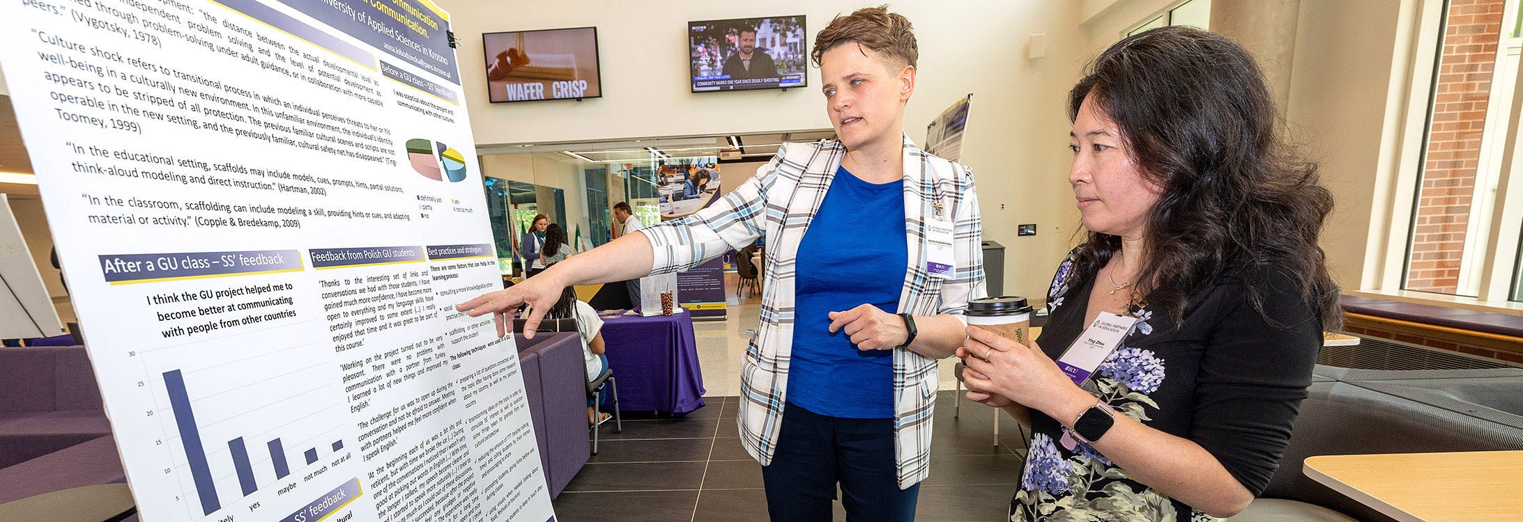 Anna Lobozinska, left, discusses her research with Ying Zhou during the 16th annual Global Partners in Education Conference inside East Carolina University's Main Campus Student Center. (ECU photo by Rhett Butler)