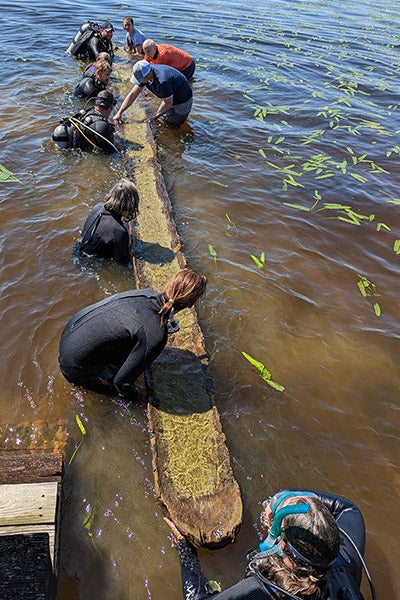 A team of divers and volunteers helped remove the canoe from Lake Waccamaw in April.