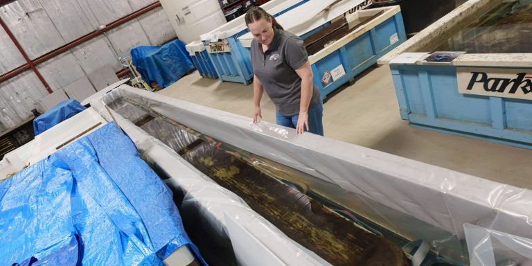 Kim Kenyon, head conservator for the Queen Anne’s Revenge project at East Carolina University's West Research Campus, looks over a canoe recovered from Lake Waccamaw.