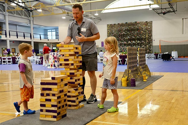 East Carolina Univeristy alum Nick Steward and his children, Hudson and Kendall, play a game of giant Jenga during the Chancellor’s Society event at the Eakin Student Recreation Center. 