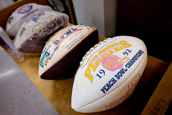 Commemorative footballs from various bowl games, including the 1992 Peach Bowl won by East Carolina over N.C. State, 37-34.