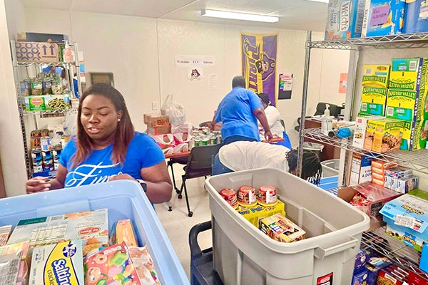 Sorority members unload and organize donated food items at the ECU Community School. 