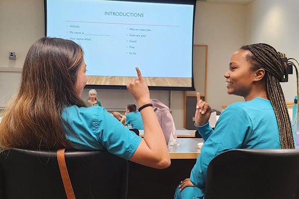 East Carolina University dental students Valeria Del Castillo, left, and Amiya Cunningham participate in a sign language introduction course as part of the ECU School of Dental Medicine’s chapter of the Special Care in Dentistry Association.