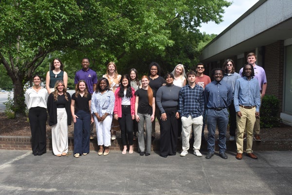 Twenty men and women pose for a group photo.