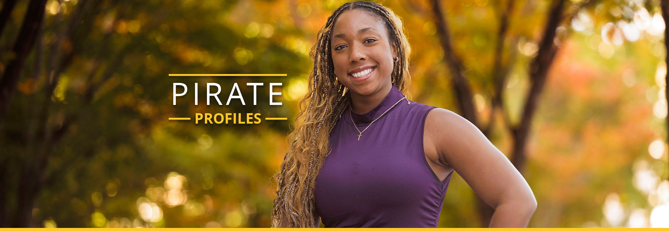 Woman posed in front of trees on campus.