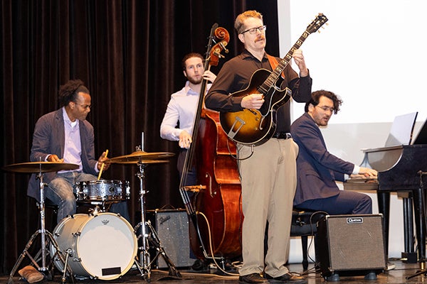 School of Music faculty members Kobie Watkins (drums), Jake Thompson (bass), Chip Newton (guitar) and Andrew Berinson (piano) perform at faculty convocation. (ECU photo by Rhett Butler)