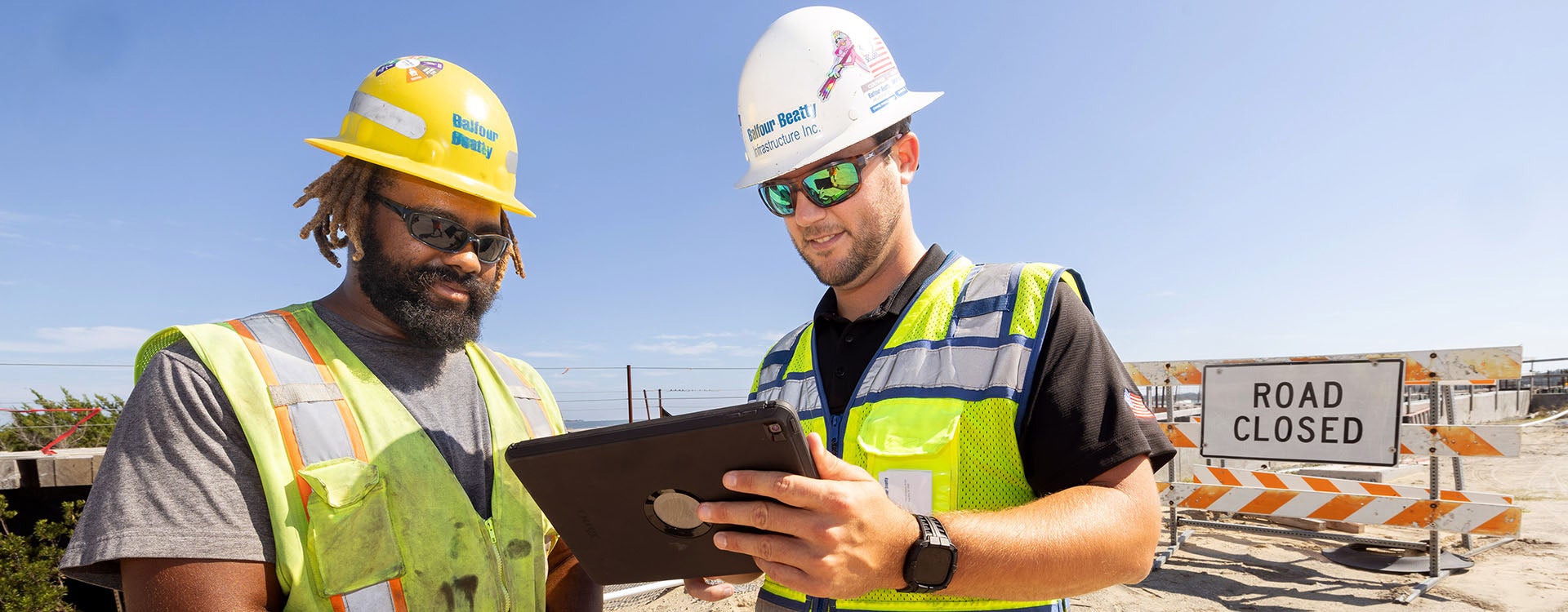 Will Janning, right, discusses work with Andrew Wright at the Harkers Island bridge replacement project. Janning has been part of the project since it started in 2021, helping write and execute contracts and working as a member of the on-site management team. (Photo by Rhett Butler)