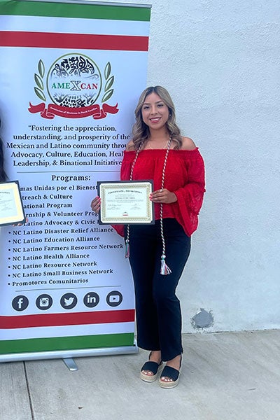 Alondra Torres receives a certificate from AMEXCAN after completing her summer internship. (Contributed photo)