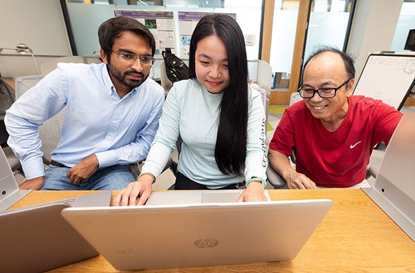 Dr. Yong Zhu, right, works with biology graduate students Muhammad Kamran and Tram Le in the Life Sciences and Biotechnology Building.