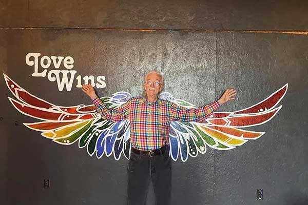 Jesse Peel poses at a mural during a Love Wins fundraiser. Peel, who died in December, supported ECU and the region’s LGBTQ community for four decades.