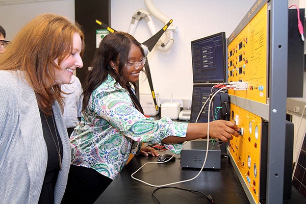Ariel Lineberger, right, demonstrates equipment to Melissa Nolan, pollution prevention specialist in the Center for Sustainable Energy and Environmental Engineering, in the Science and Technology Building. (Photo by Ken Buday)