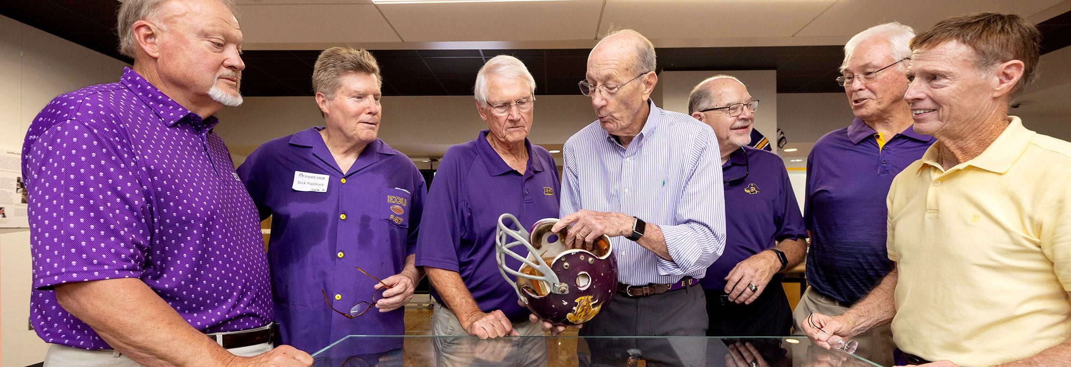 Grover Truslow talks to East Carolina University football teammates about the helmet he wore in the 1970 ECU-Marshall game. ECU and Marshall play this weekend at 4 p.m. at Dowdy-Ficklen Stadium. (ECU photo by Rhett Butler)