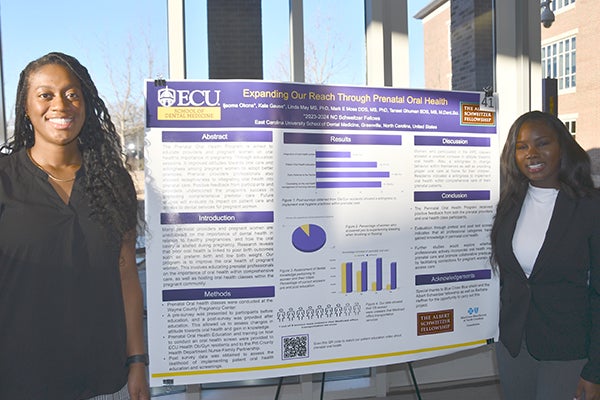 Dental student Ijeoma Okons, left, and classmate Kala Gause present their research during the school’s Celebration of Research and Scholarship earlier this year. (Photo by Jon Jones)