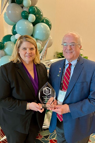 Dr. Sharon Paynter and David Spalding showcase the IEP award with smiles.