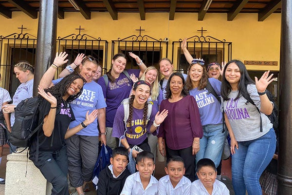 College of Nursing students pause for a photo outside of a school in Guatemala they visited to give a health promotion class.