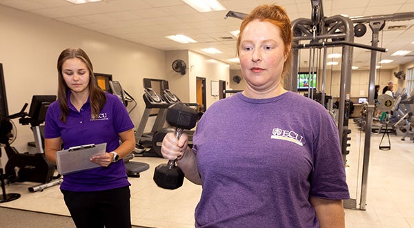 Kinesiology student Kelly Clark observes as Melissa Nolan participates in a strength exercise routine.