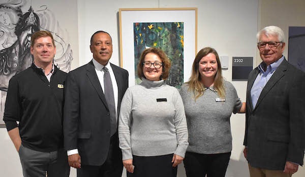 Group photo of three men and two women posing for the camera.