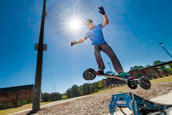 Johnnie Sabin takes a break from research while riding his mountainboard at Wildwood Park.
