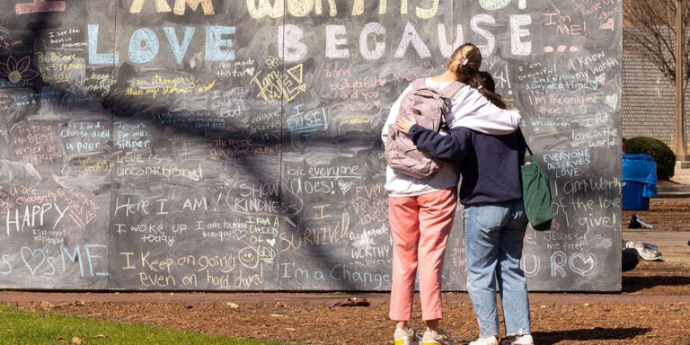 East Carolina University students look at a chalkboard of messages during a mental health awareness event in February. (ECU photo by Rhett Butler)