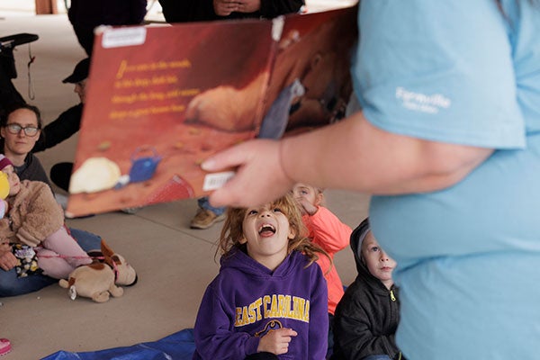 Kids sit and listen to “Bear Snores On” read to them.