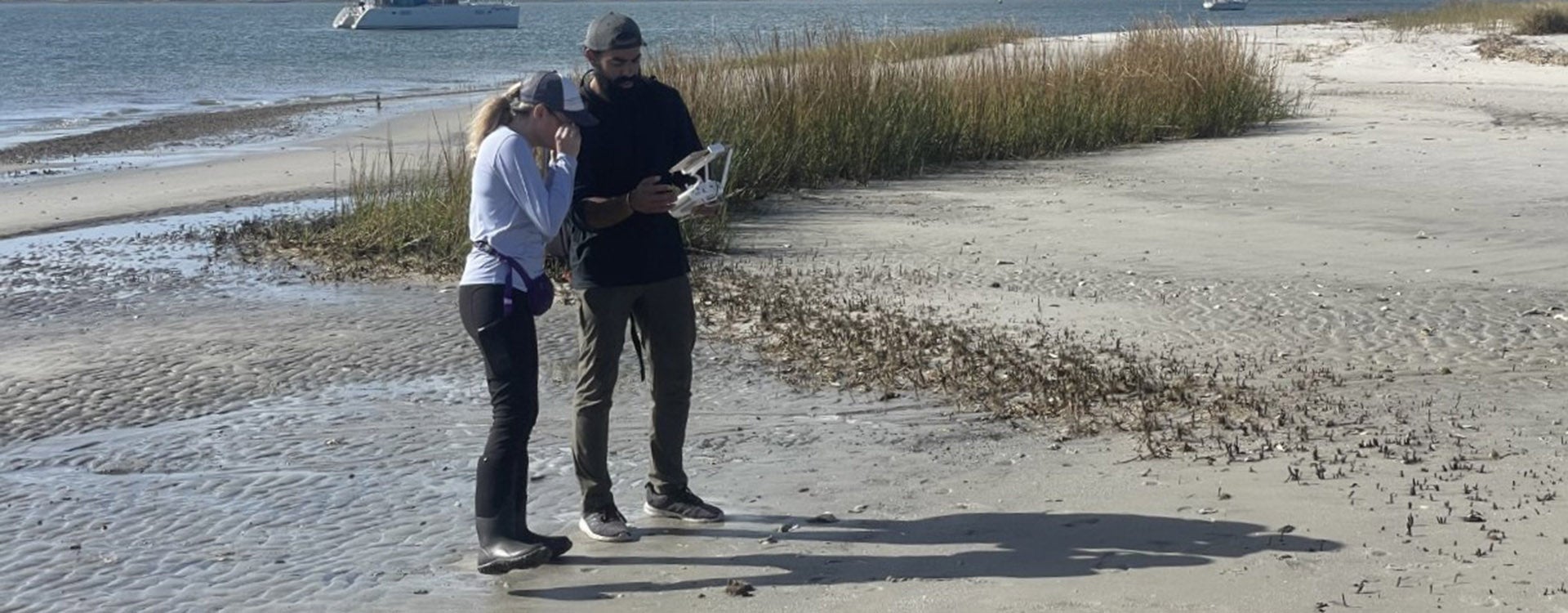 Dr. Hannah Sirianni, left, reviews the automatic flight parameters with Moody before he conducts a scientific drone survey of Sugarloaf Island. 