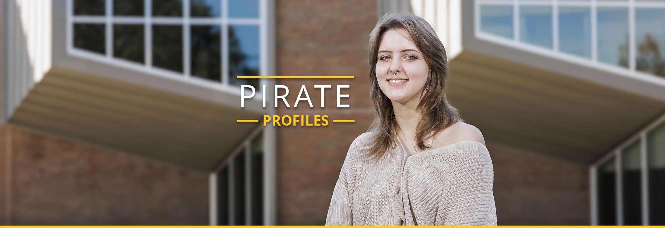 Senior Grace Scott smiles while standing in front of the Jenkins Fine Arts Center.