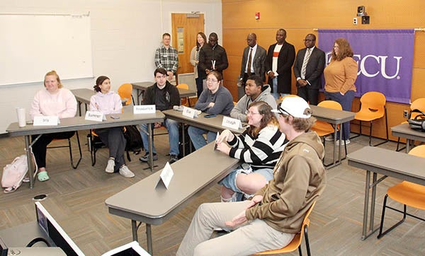 Representatives from the University of The Gambia stand and observe a class in which ECU students collaborate with university students in Poland. (Photo by Ken Buday)
