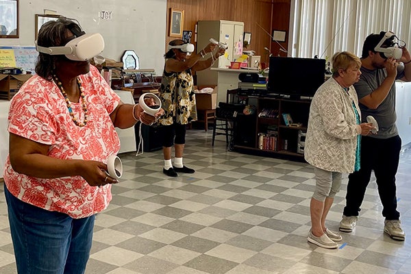 Older adults using virtual reality headsets in a room at Sunrise Senior Living.