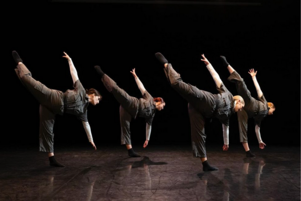 Four students stand in intricate positions as they perform on stage at ECU’s McGinnis Theatre